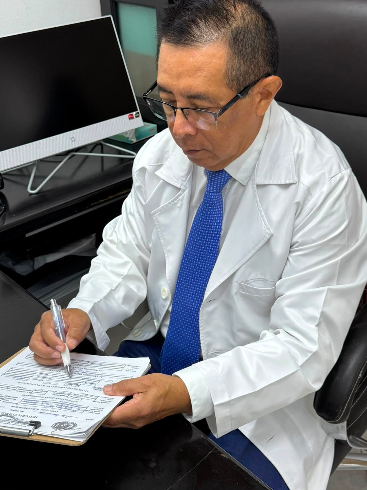 Dr. Carlos Alejos revisando documentación clínica
