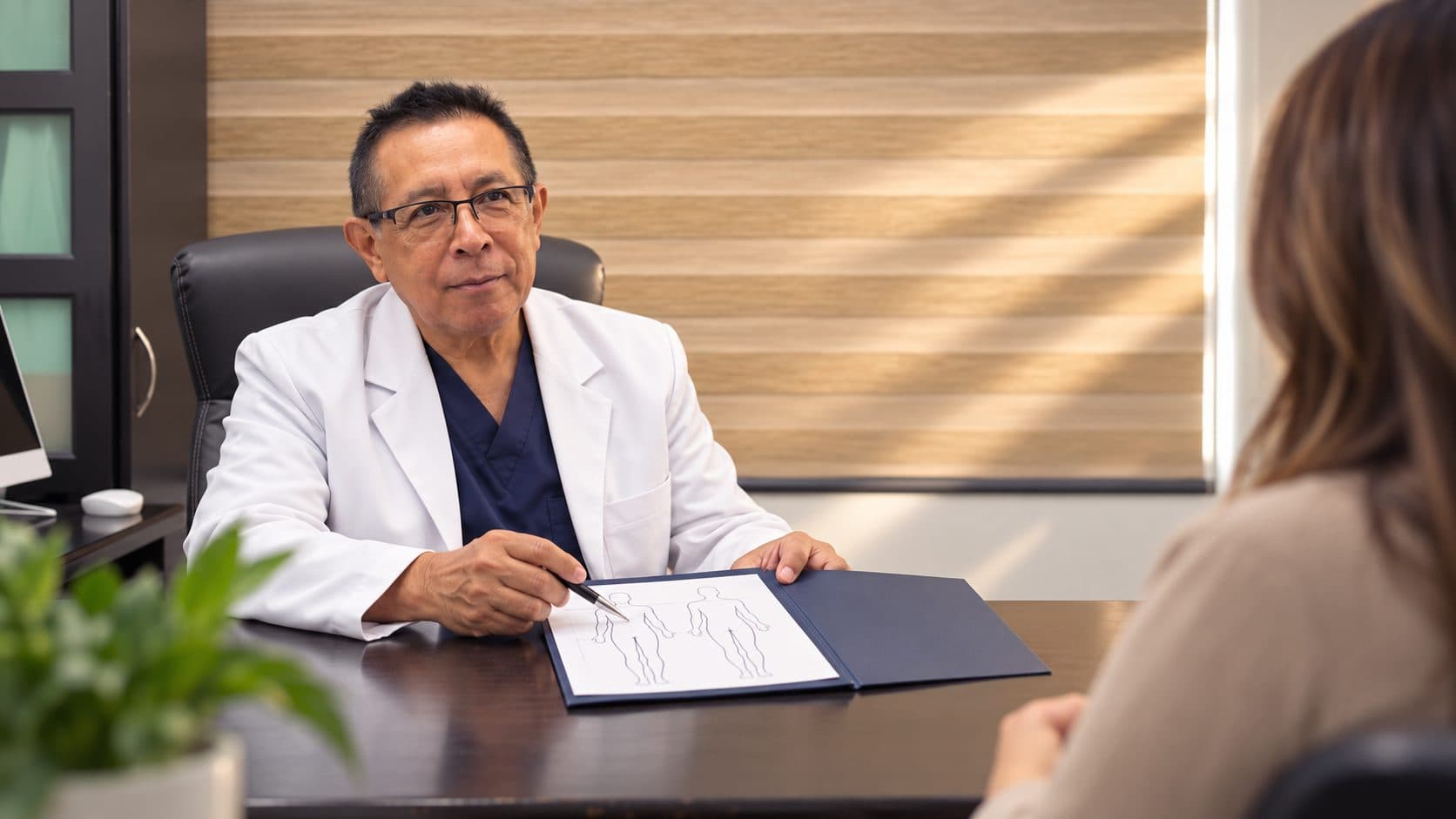 Dr. Carlos Alejos explicando un procedimiento a una paciente