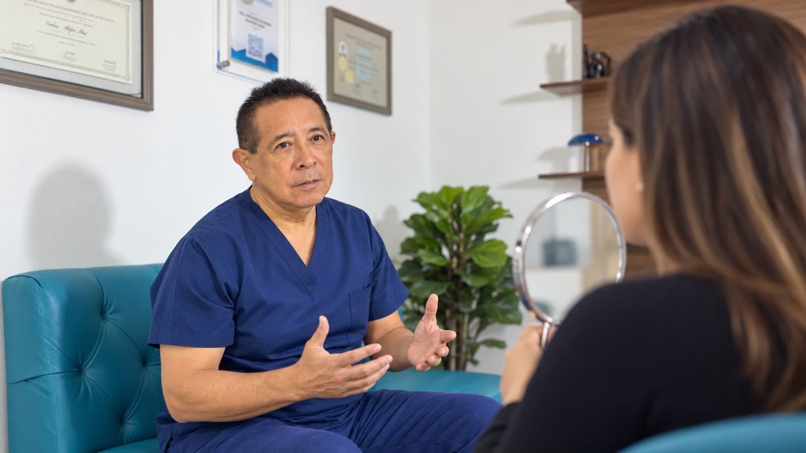 Dr. Carlos Alejos mostrando a una paciente su valoración con un espejo